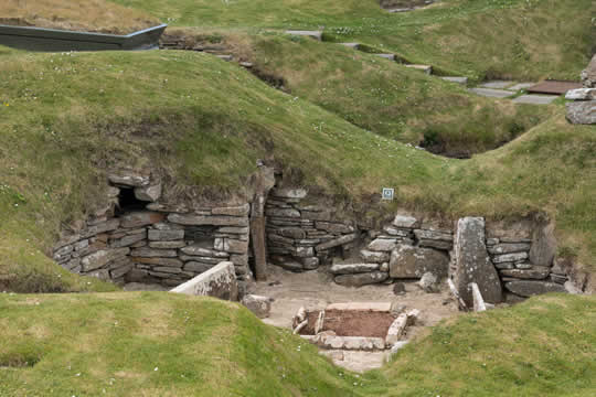 large stones forming walls, set into a grassy hill