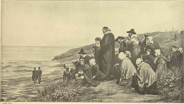 pen and pencil sketch of a group of about 20 people in 17th century Puritan garb, standing and sitting on the narrow, sandy coast of the Atlantic Ocean. Most of them have their heads bowed prayerfully.