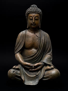 statue of a seated man with his hands clasped