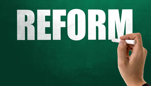 A hand writing the word "Reform"