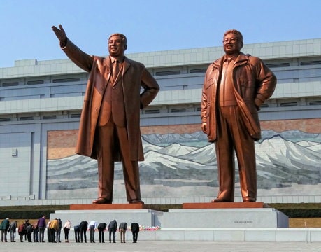 huge statues of two men, one with an outstretched arm