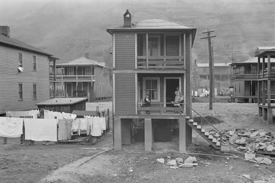 small two-story buildings surrounded by trash and hanging laundry