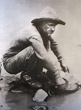 photograph of a man panning for gold