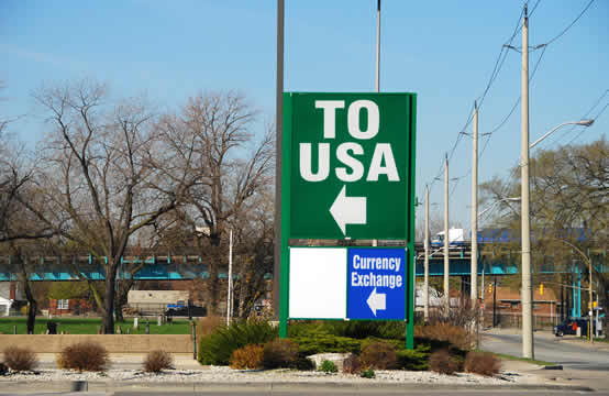 sign on street corner indicating the way to the U.S.