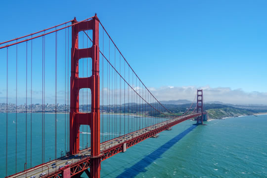 a red bridge spans a large expanse of water