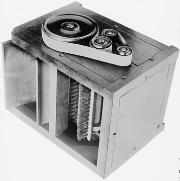 box-shaped machine with belts on top and an open side