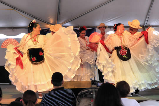 men and women in fancy clothing dancing on a stage