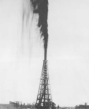 oil spouting from the top of a metal tower