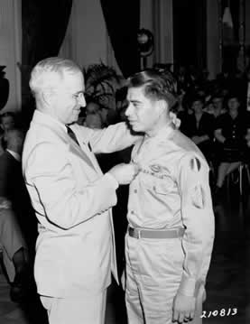 a man giving a medal to a man in uniform