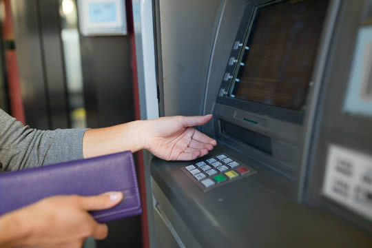 a hand waiting to receive money from a cash machine