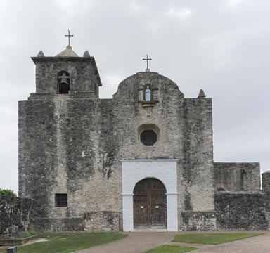 exterior of an old stone building with crosses on top