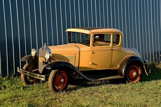 a yellow vintage automobile from the 1920s