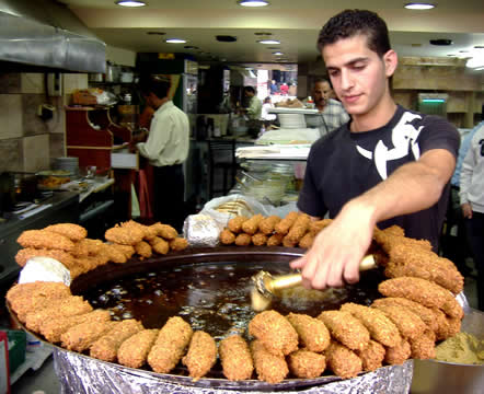 man serving food from a large platter in a restaurant