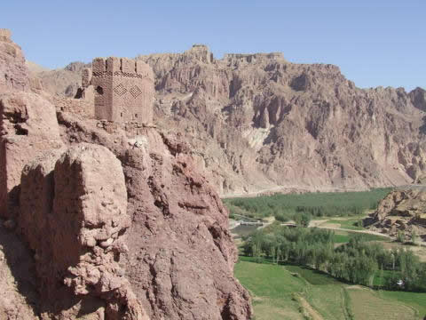 fortified building on a bare mountain with green below