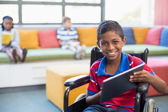 boy in wheelchair holding a tablet