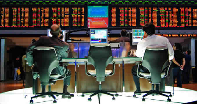 several people, seated, watching large screens