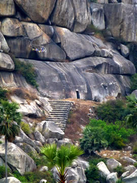 rough steps leading to a huge stone wall