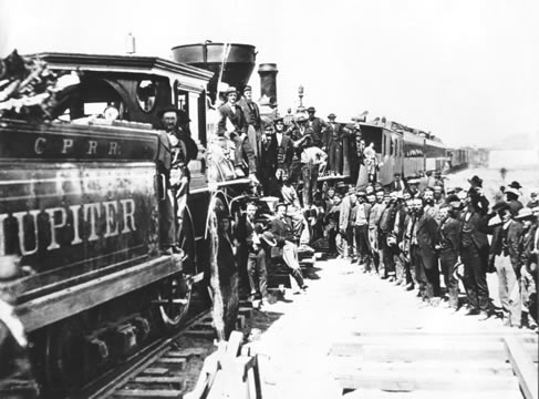 photograph of group of people alongside a railroad engine