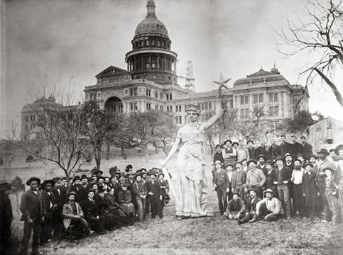 many people looking at a statue of a woman