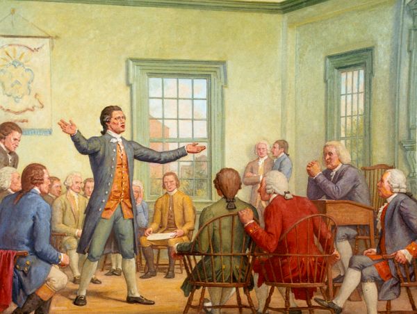 An oil painting shows a man in a blue coat standing and passionately speaking to a group of seated men in a wooden room. Most of the men in the painting are wearing jackets, breeches, and white shirts with ruffled cuffs.