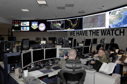 men sitting at screens with maps all around