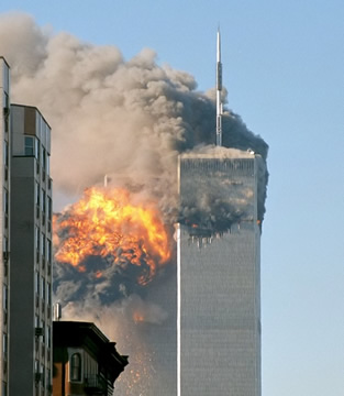 two tall buildings against the sky with a ball of fire and black smoke arising from the top floors