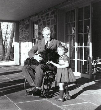 photograph of FDR in a wheelchair alongside a child
