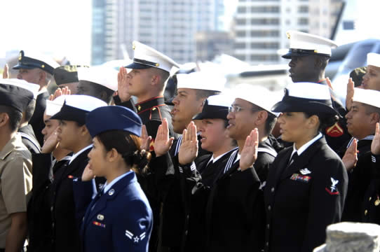 a groups of U.S. soldiers in uniform raise their right hands while taking the oath of allegiance