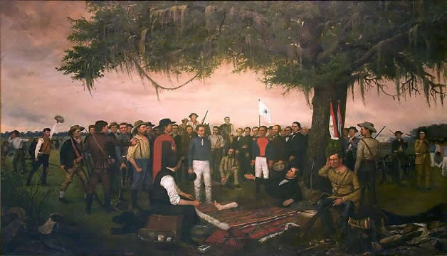 many men look on as two men discuss matters. One is lying on the ground