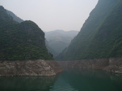 a river narrows through forested mountains